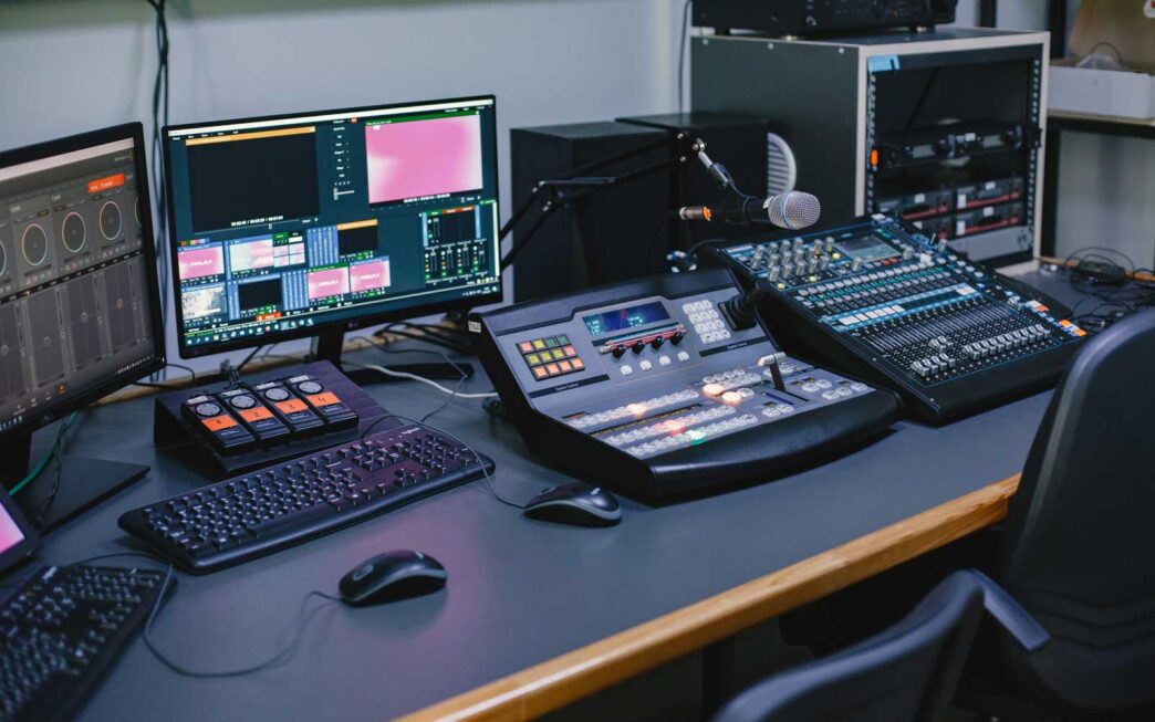 Table in a media house with screens and mixers