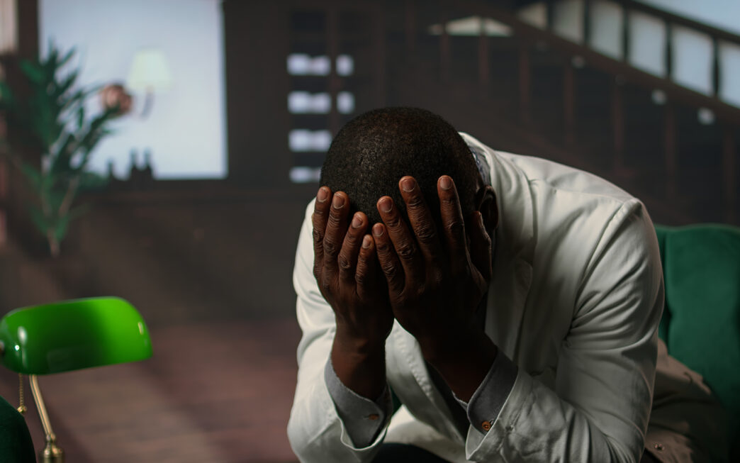 A man covering his face with his hands expressing disappointment