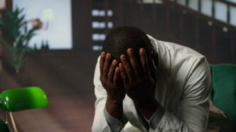 A man covering his face with his hands expressing disappointment